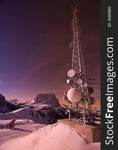 A large antenna on top of a snow-capped mountain. A large antenna on top of a snow-capped mountain