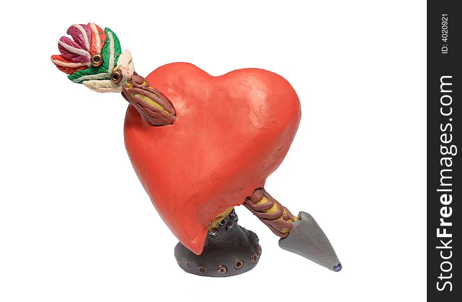 The plasticine heart punched by an arrow.Symbol of love.Manual moulding. The plasticine heart punched by an arrow.Symbol of love.Manual moulding.