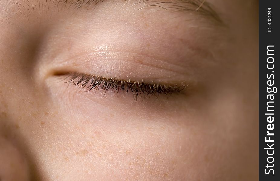 Closeup of a young boy's eye that is closed. Main focus is on the eyelashes. Closeup of a young boy's eye that is closed. Main focus is on the eyelashes.