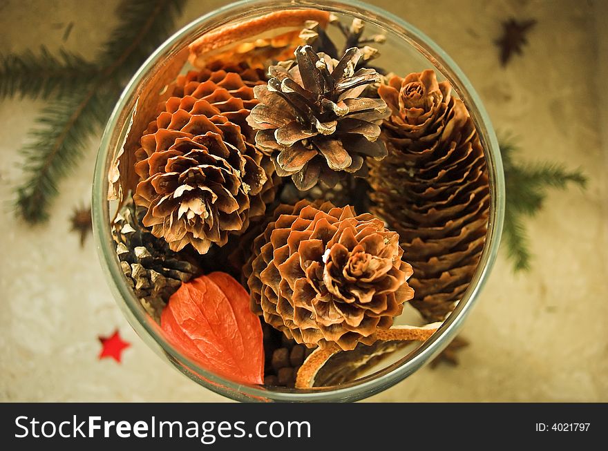 Glass container filled with pine cones and physlais fruit, shot from above. Glass container filled with pine cones and physlais fruit, shot from above
