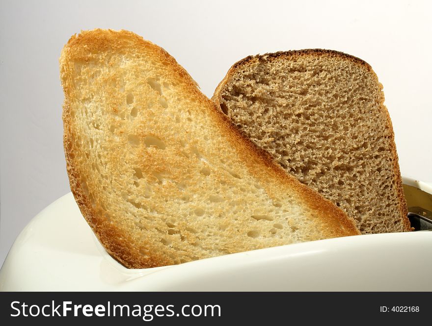 White toaster with white bread toast and rye-bread toast on white background