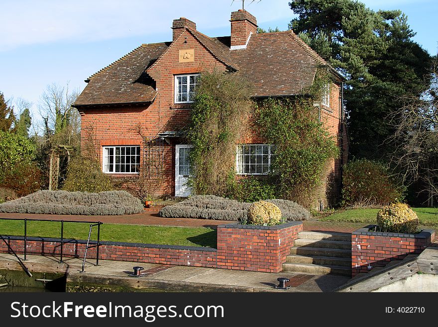 Lock keepers house on the River Thames in England with a pretty garden to the front