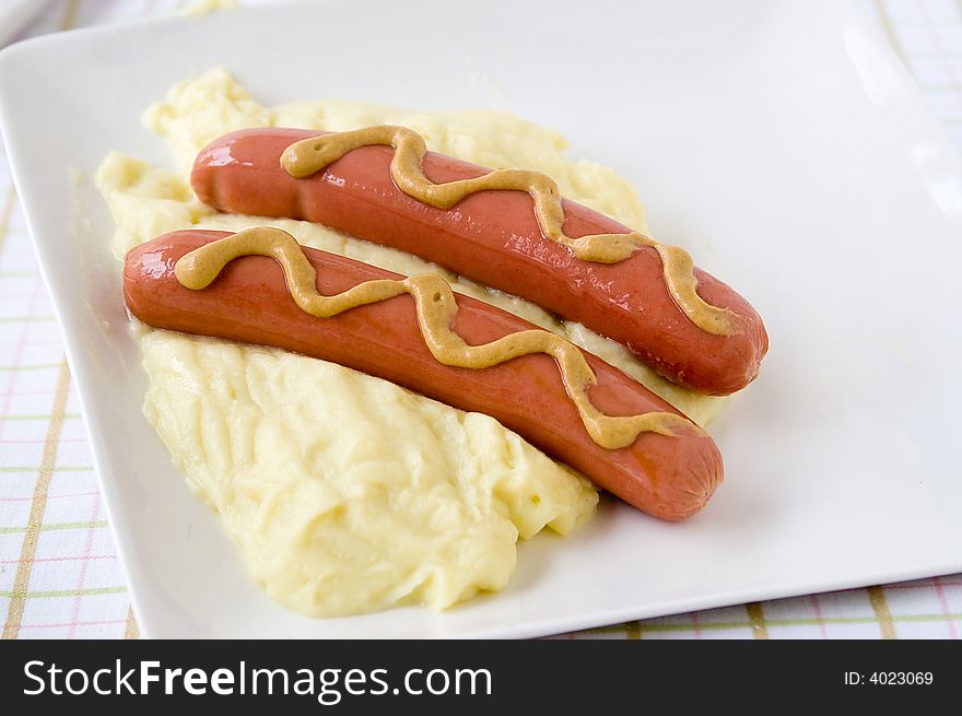 Frankfurter sausage over puree from potatoes in a dish