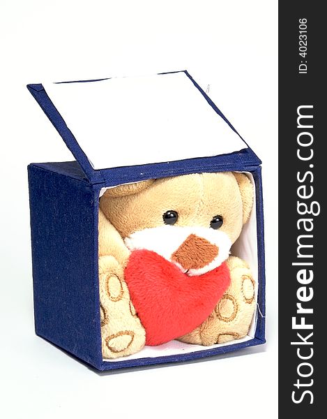 Soft toy - bear. In an open blue box. The gift of Valentine `s Day. At a homogeneous background. Soft toy - bear. In an open blue box. The gift of Valentine `s Day. At a homogeneous background