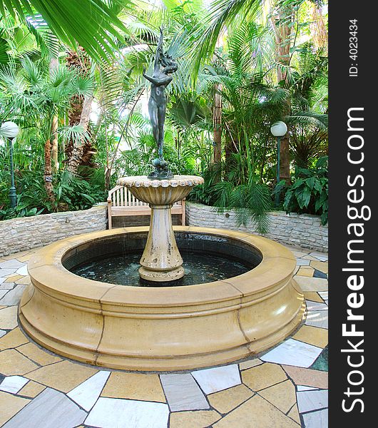A picture of a beautiful Fountain surrounded by greenery