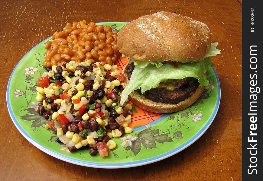 A plate with hamburger and sides from a typical barbecue. A plate with hamburger and sides from a typical barbecue.