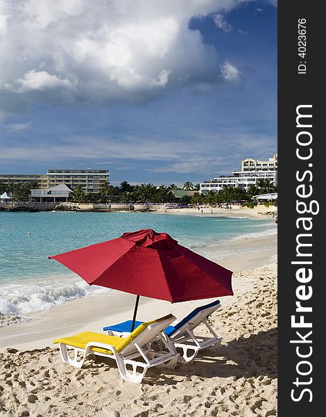 Two colorful chairs and umbrella on resort beach, St. Martin. Two colorful chairs and umbrella on resort beach, St. Martin