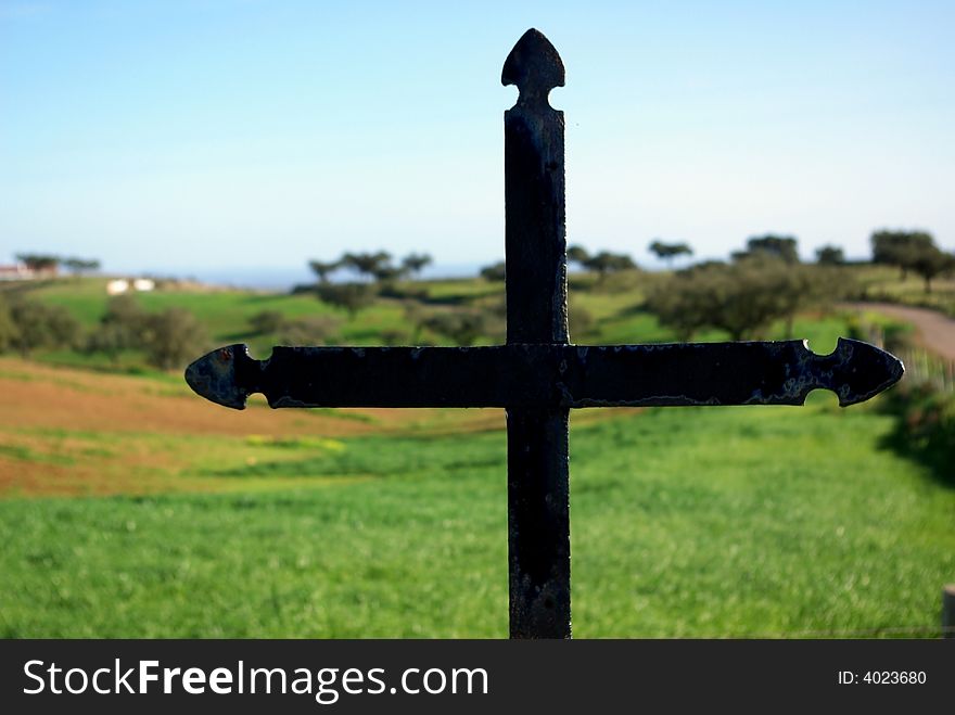 Metal cross overlooking a countryside in Portugal. Metal cross overlooking a countryside in Portugal.