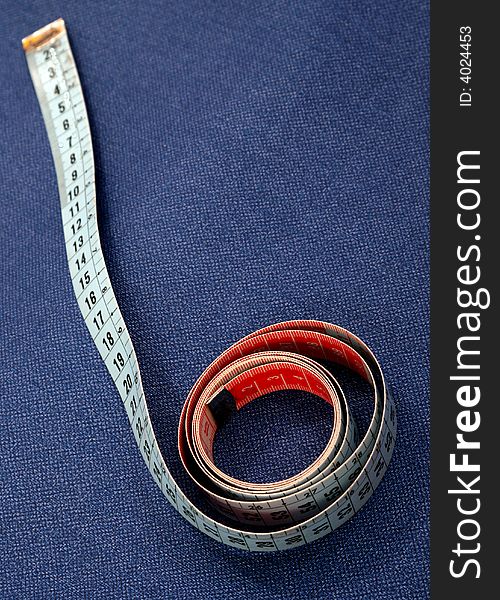 Measuring tape coiled on blue