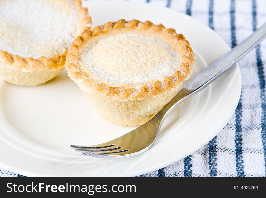 Two mince pies with a fork on a plate. Two mince pies with a fork on a plate