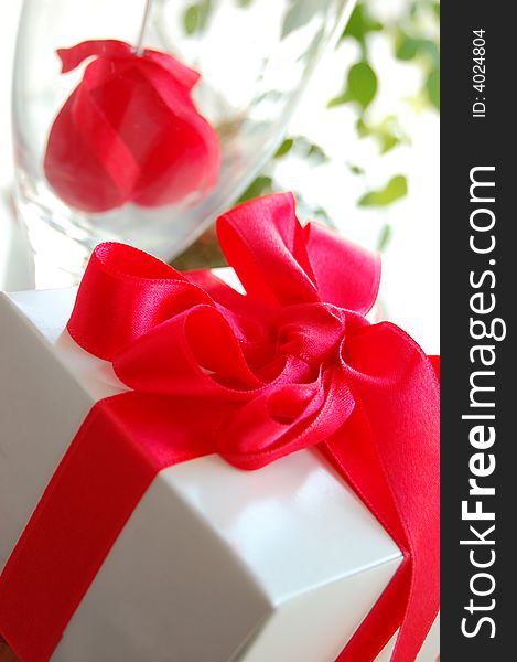 Gift box with red ribbon and fabric heart inside the glass. Gift box with red ribbon and fabric heart inside the glass