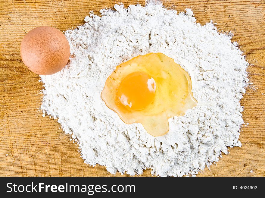 Flour and eggs on a wooden board