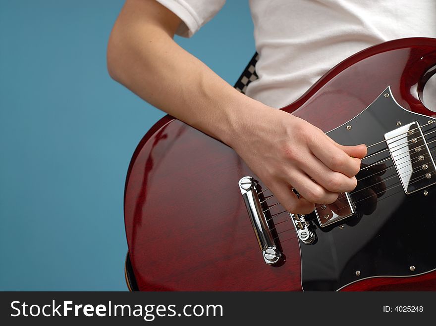 Horizontal shot of an electric guitar closeup with a male playing hand