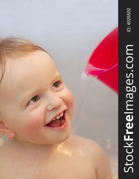 Baby in bathroom washing with water