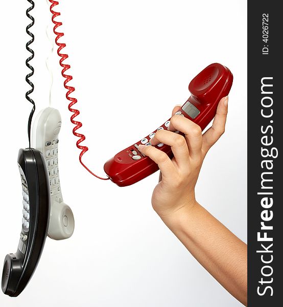 Handset phones hanging over a white background. Handset phones hanging over a white background