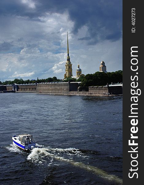 View to the Peter and Paul fortress from Troitsky bridge. Boat sailing over the Neva river.