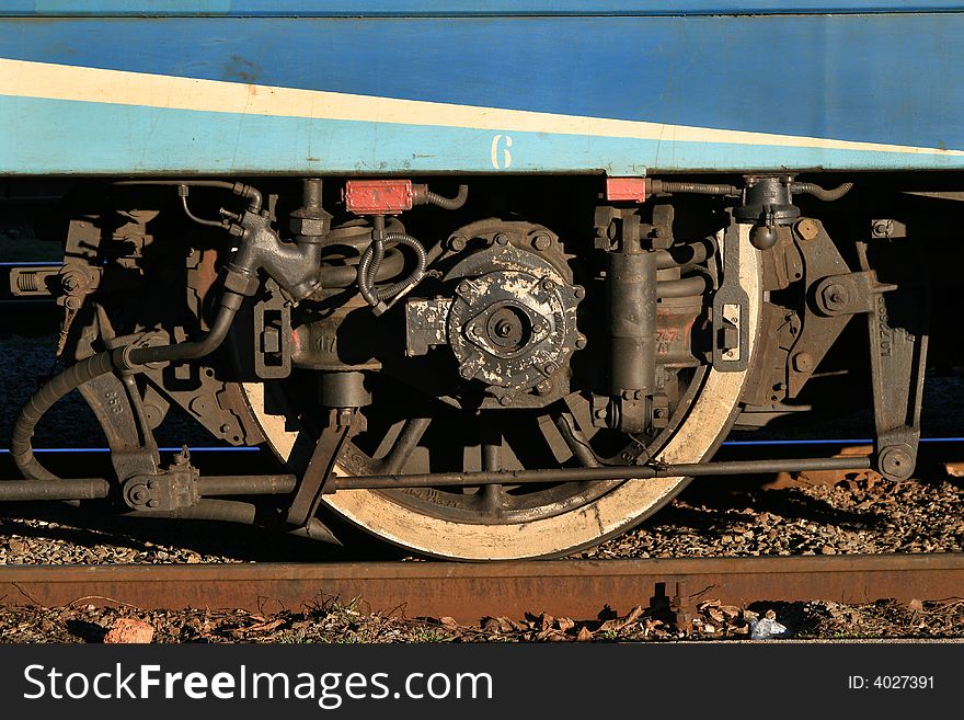 Wheel of a train costing at station. A fragment of the locomotive