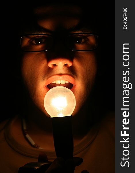 Guy in the dark whit light in front of his mouth. Guy in the dark whit light in front of his mouth