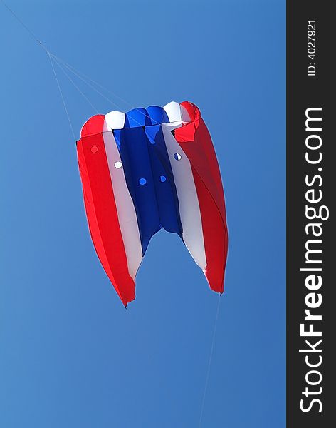 Red, white and blue kite on a blue sky background. Red, white and blue kite on a blue sky background
