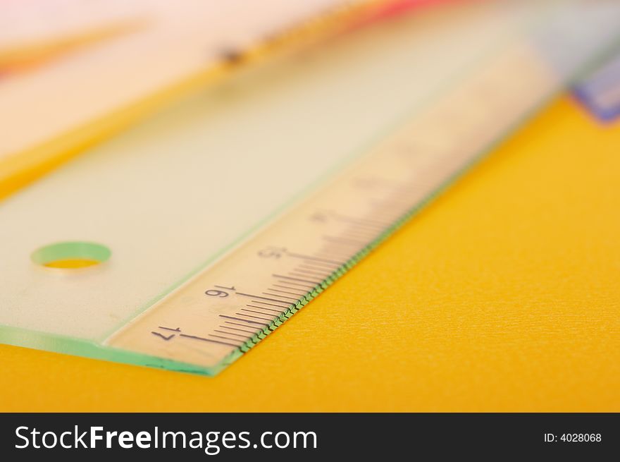 Plastic ruler on a yellow gold background