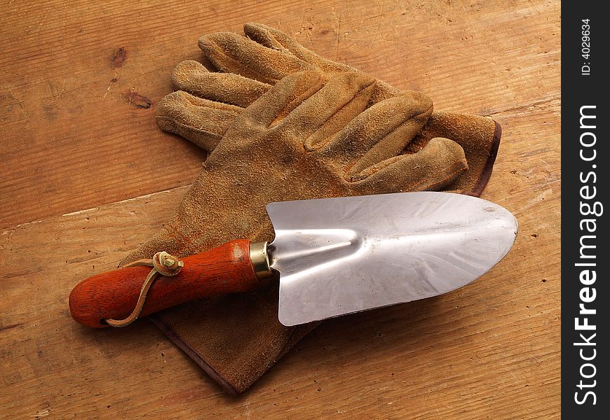 Two Work gloves crossed on wood with mini shovel. Two Work gloves crossed on wood with mini shovel