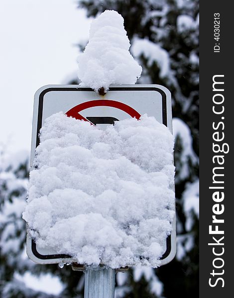 A sign warning drivers not to park cars on the road is obscured by a winter storm. A sign warning drivers not to park cars on the road is obscured by a winter storm