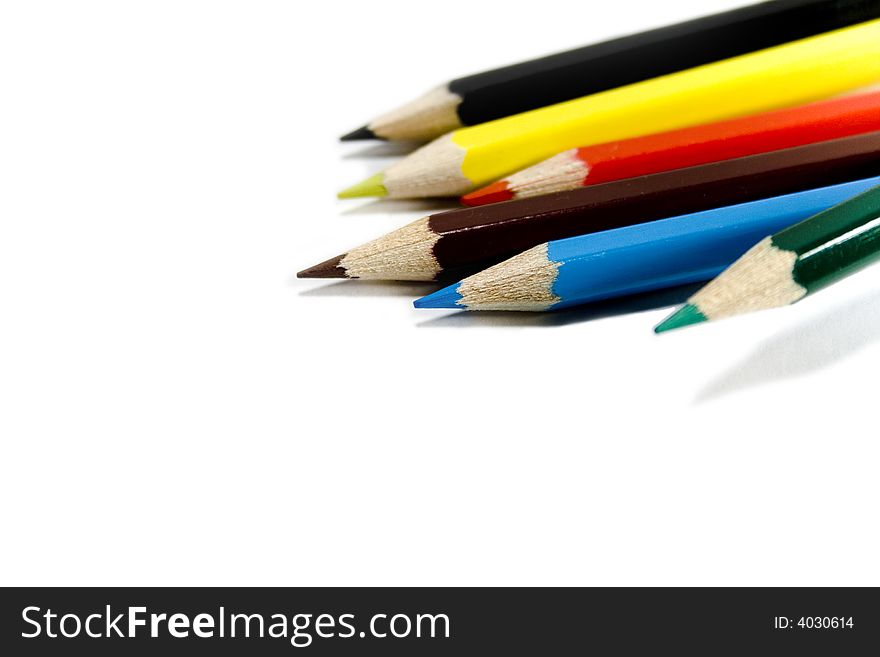 Six coloured pencils over white background