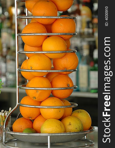 Many oranges in a special container at a bar counter. Many oranges in a special container at a bar counter