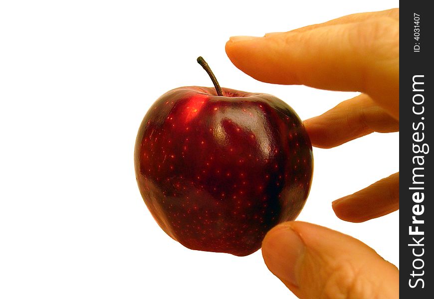 Hand stretched out towards nice red apple. Hand stretched out towards nice red apple