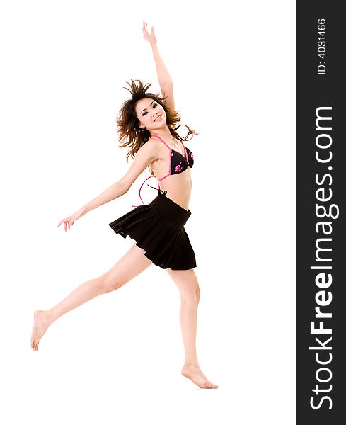 Young woman in bikini top & skirt jumping freely and happily. Young woman in bikini top & skirt jumping freely and happily