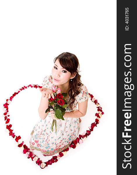 Young woman with roses sitting inside a rose petal heart shape. Young woman with roses sitting inside a rose petal heart shape