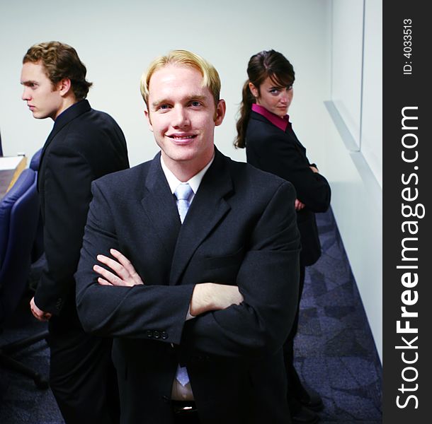 Small group of business people standing with arms folded. Small group of business people standing with arms folded.