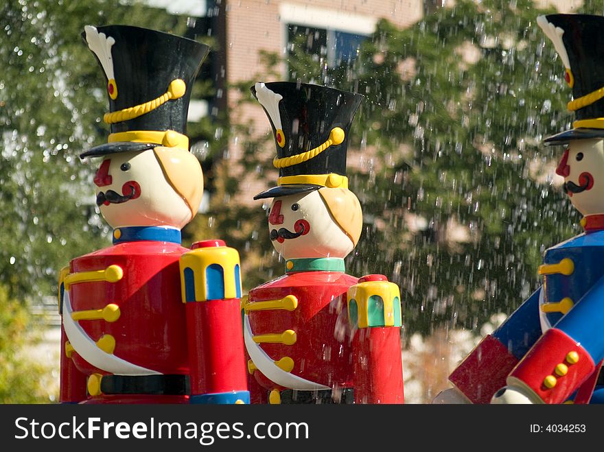 Three colorful mannequins used to decorate a fountain during the Christmas holiday. Three colorful mannequins used to decorate a fountain during the Christmas holiday.