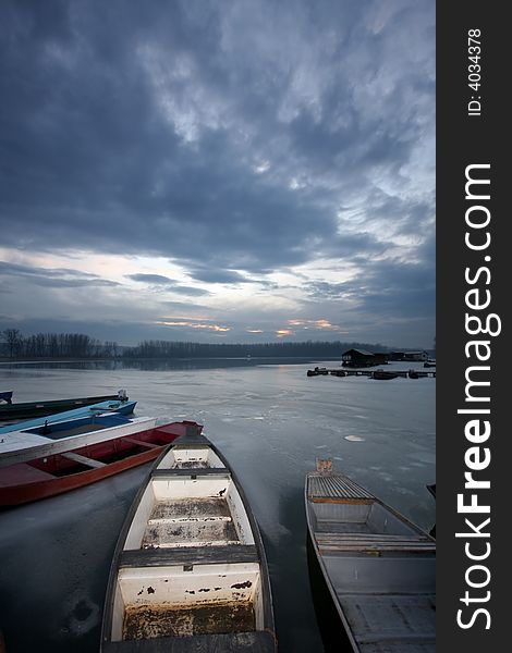 Old boat on frozen river Danube in january