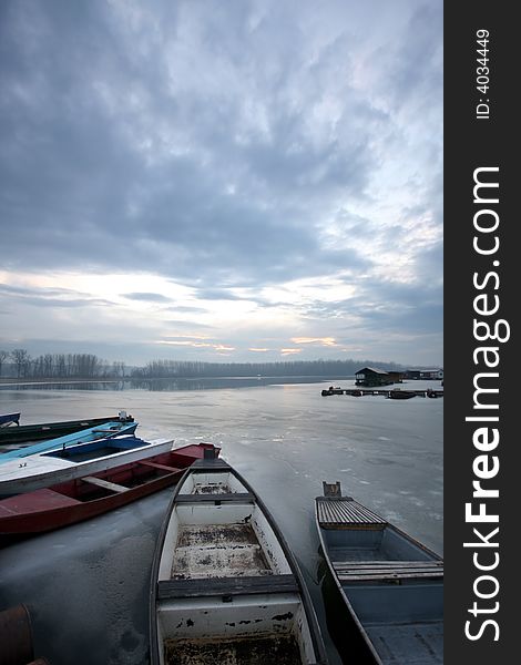 Old boat on frozen river Danube in january