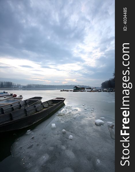 Old boat on frozen river Danube in january