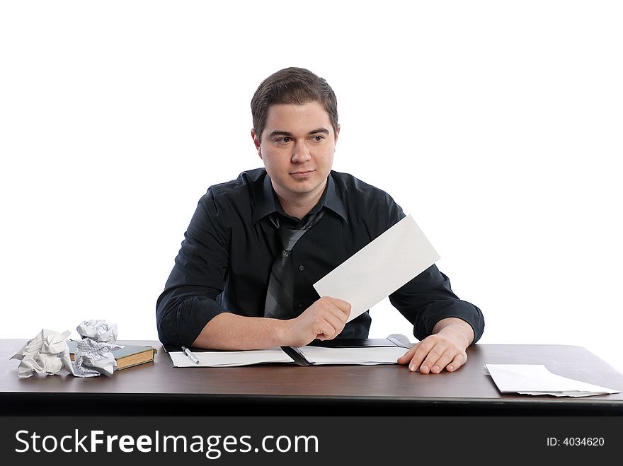 Business man sitting at desk tossing up paper. Business man sitting at desk tossing up paper