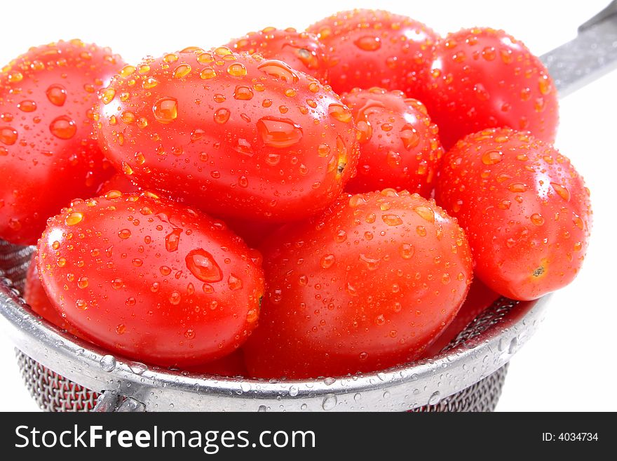 Close up of a group organic grape tomatoes in a strainer.