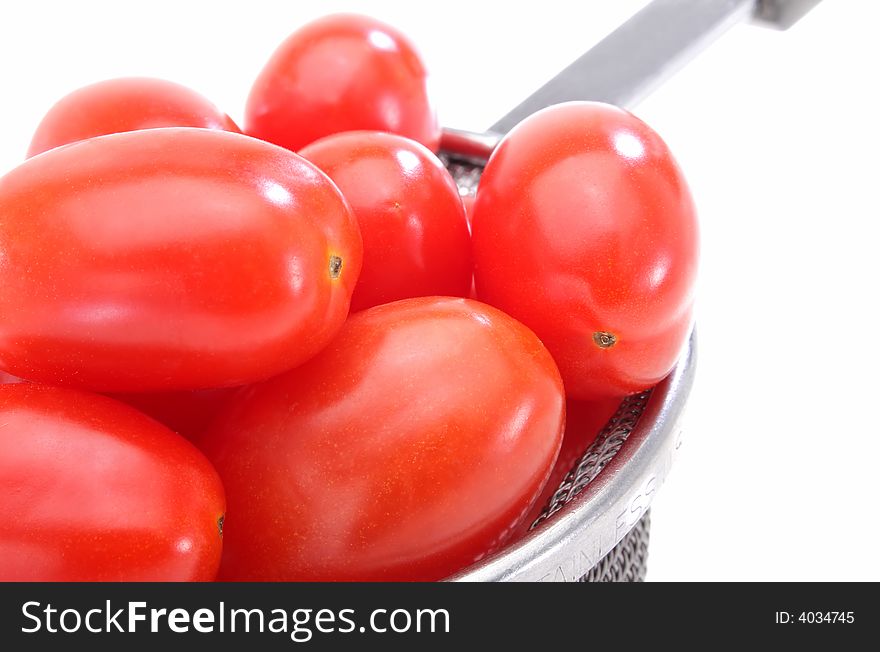 Close up of a group organic grape tomatoes in a strainer.