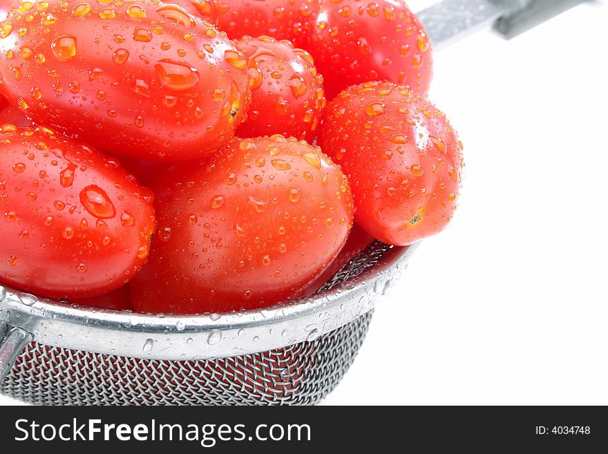 Close up of a group organic grape tomatoes in a strainer. Close up of a group organic grape tomatoes in a strainer.