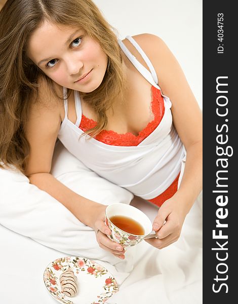 Young pretty girl drinking tea in the bed. Young pretty girl drinking tea in the bed