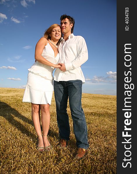 The couple stand on meadow