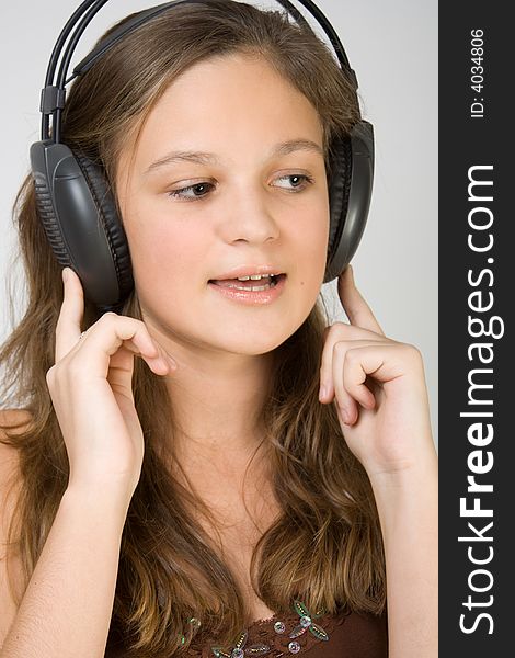 Young pretty girl listening music with headphones and singing.