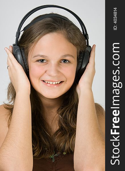 Young pretty smiling girl listening music with headphones