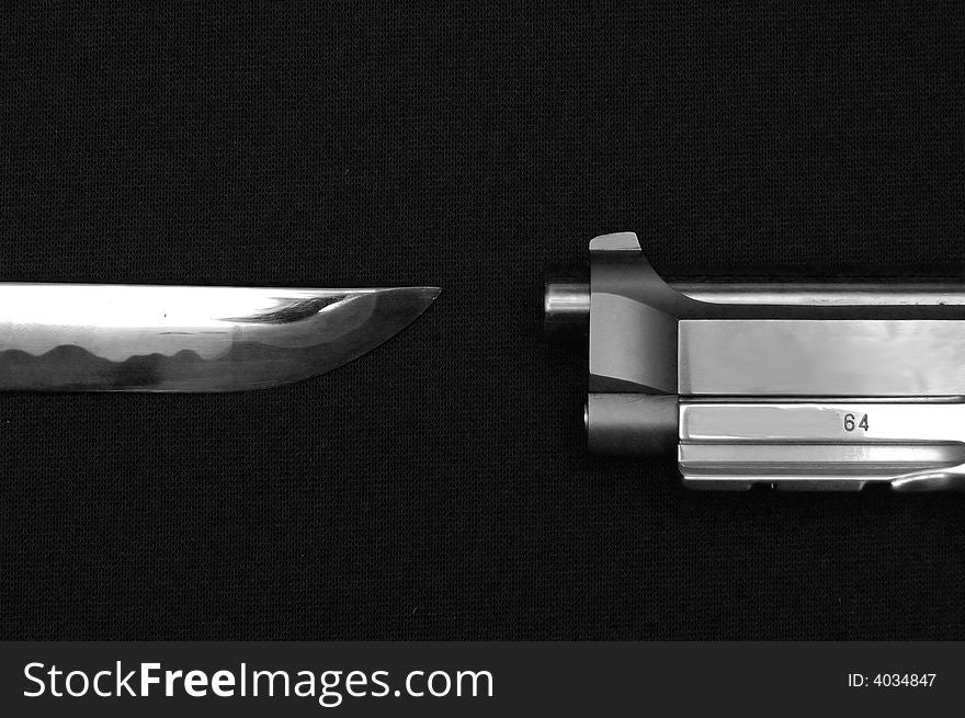 Knife And Gun Pointing Towards Each Other