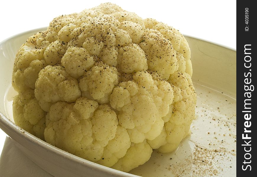 Head of boiled cauliflower on a white plate