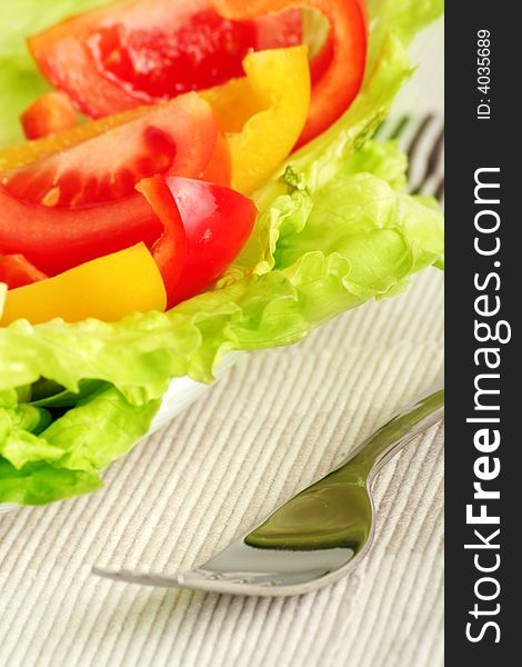 Fresh green salad with tomatoes and pepper and a fork. Fresh green salad with tomatoes and pepper and a fork