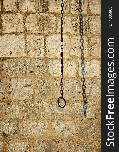 Brick wall background with rusty chain and shadow