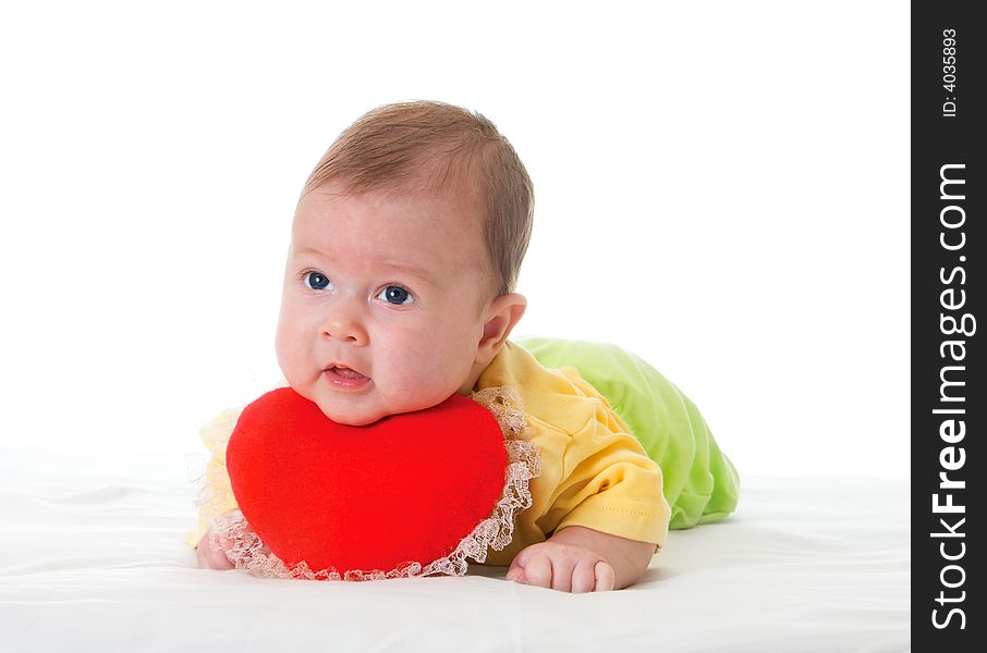 Baby with a soft toy in the form of heart over white