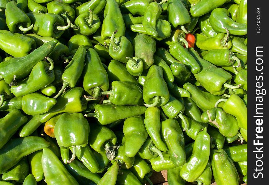 Lots of green peppers, taken in a market